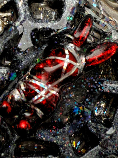 Close-up of a decorative dog charm with red and black colors, a piece of dog jewelry art.