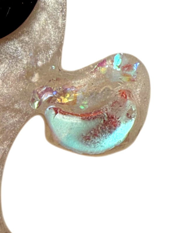 Close-up of a dog jewel tag ghostie with iridescent finish on a white background