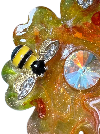 Decorative dog jewel ID tag with bee design and gemstones on a colorful background