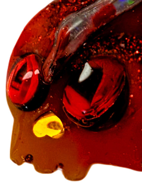 Close-up of a resin dog jewel tag with red, blue, and silver holographic colour and glitter 